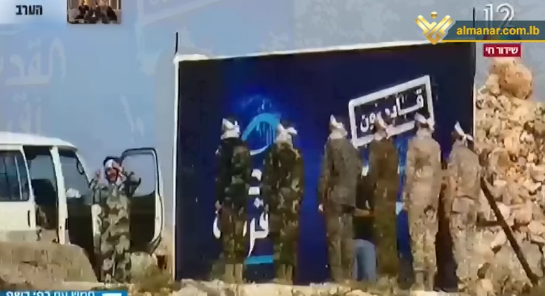 Combatientes de Hezbolá junto a un cartel en la frontera