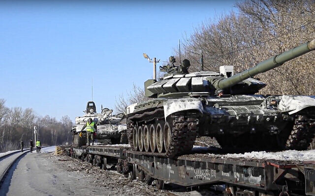 In this photo taken from video provided by the Russian Defense Ministry Press Service on Wednesday, Feb. 16, 2022, Russian army tanks are loaded onto railway platforms to move back to their permanent base after drills in Russia. Russia says it is returning more troops and weapons to bases, but NATO says it sess no sign of a drawdown as fears that Moscow could invade Ukraine soon persist. Russia has massed about 150,000 troops east, north and south of Ukraine. (Russian Defense Ministry Press Service via AP)
