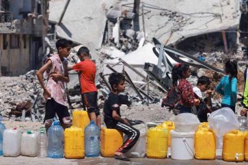 Niños palestinos hacen cola para conseguir agua en Gaza